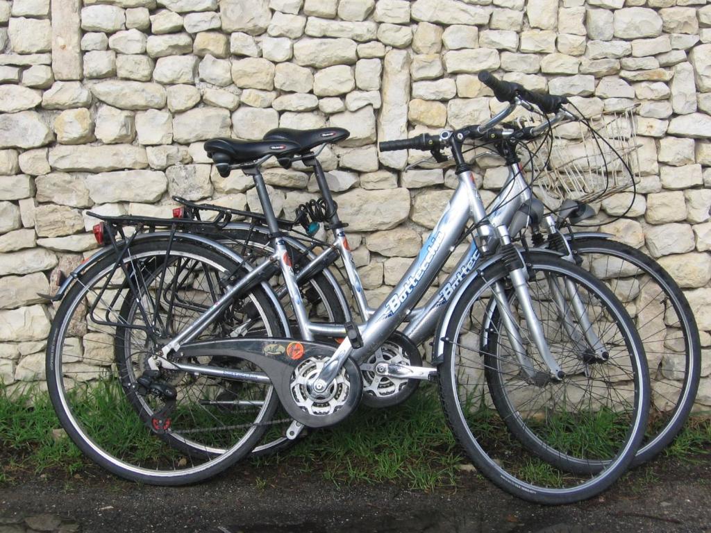 two bikes parked next to a stone wall at Les Chênes Bleus in Sainte-Marie-de-Ré