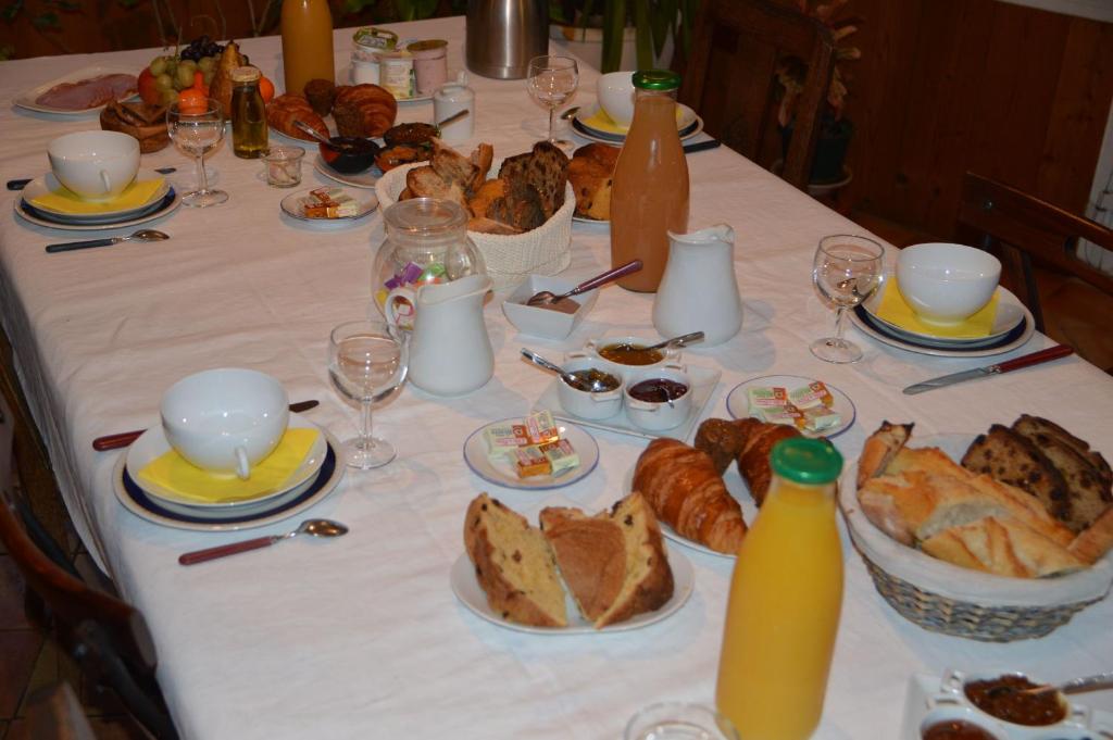 a table with a white table cloth with bread and drinks at Les Chênes Bleus in Sainte-Marie-de-Ré