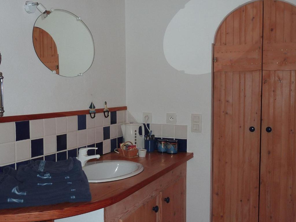 a bathroom with a sink and a mirror at Les Chênes Bleus in Sainte-Marie-de-Ré
