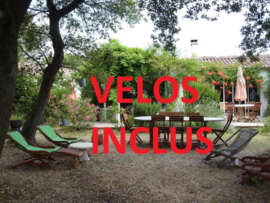a sign that reads vicos indius with chairs and a table at Les Chênes Bleus in Sainte-Marie-de-Ré