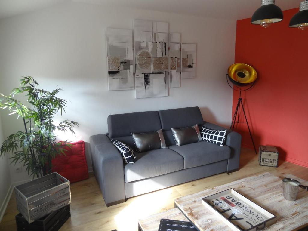 ein Wohnzimmer mit einem Sofa und einem Tisch in der Unterkunft Appartements HEMINGWAY in Avignon