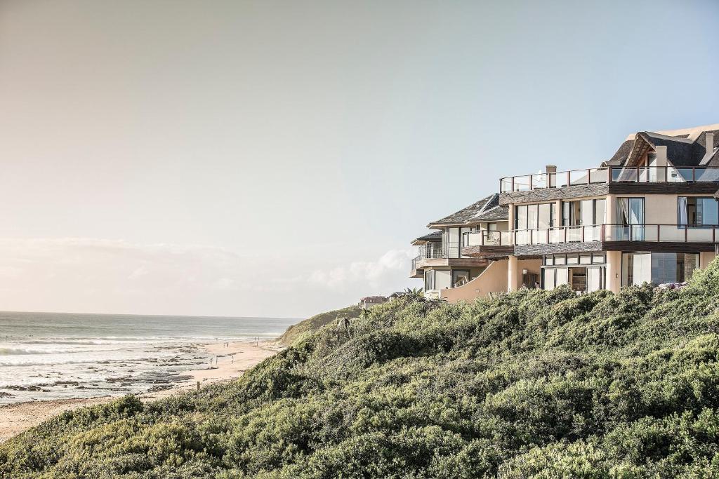 una casa en una colina junto a la playa en Dolphin Sunrise, en Jeffreys Bay