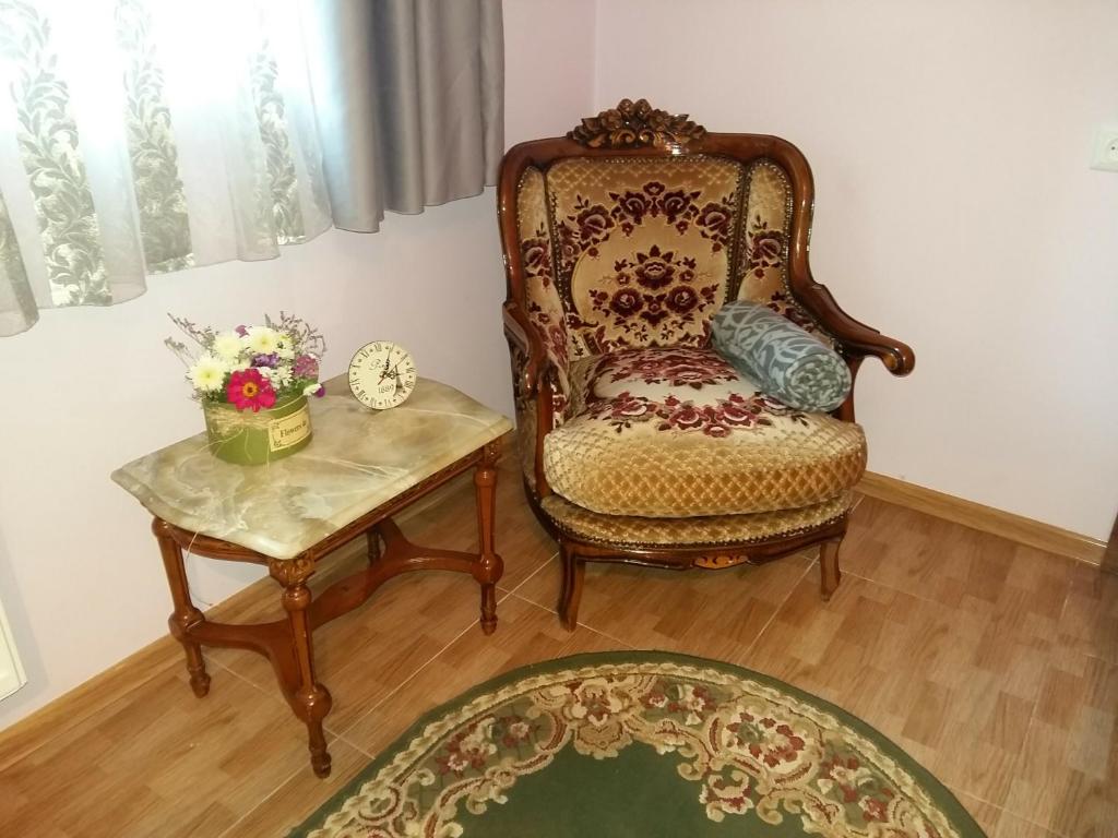 een woonkamer met een stoel en een tafel bij Guest House Panda in Koetaisi