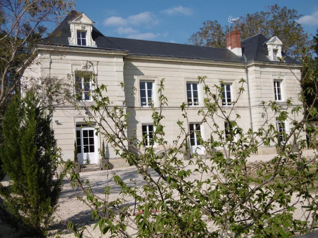 ein altes weißes Haus mit schwarzem Dach in der Unterkunft Le petit domaine des Aubuis in Chinon