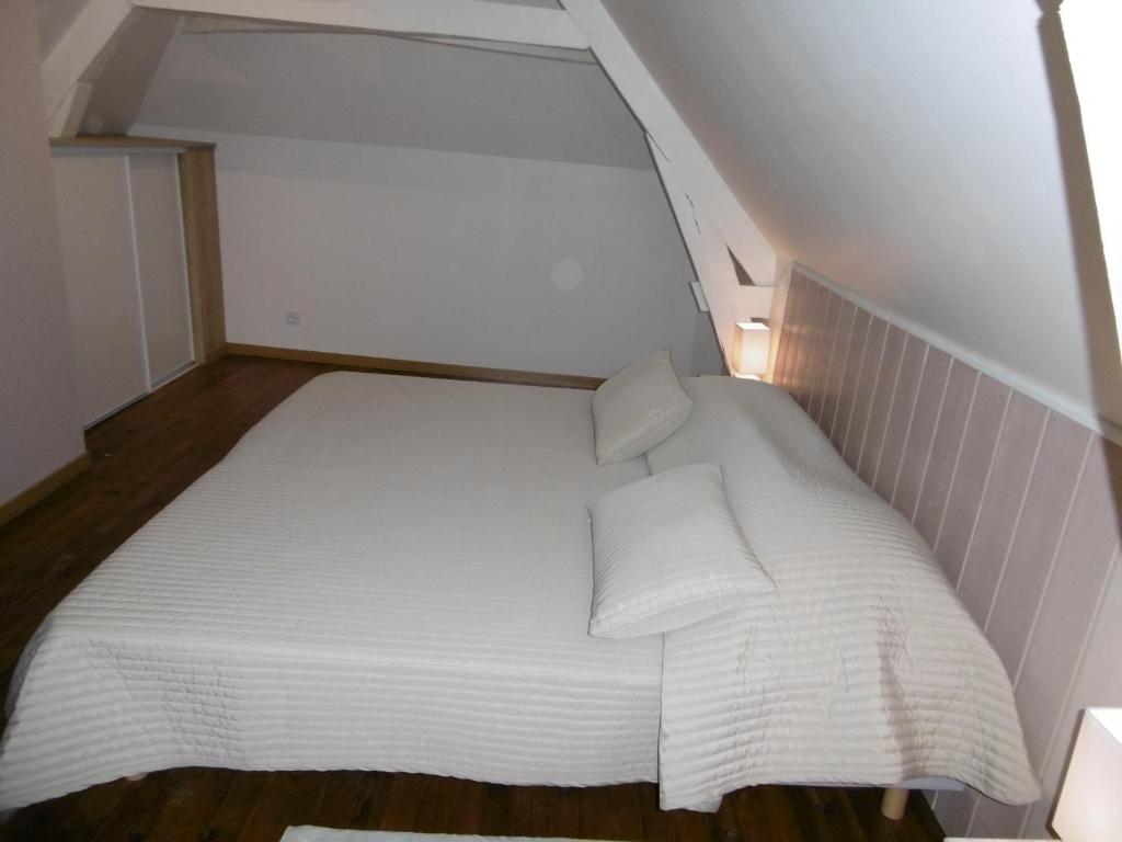 a small white bed with two pillows on it at Le petit domaine des Aubuis in Chinon