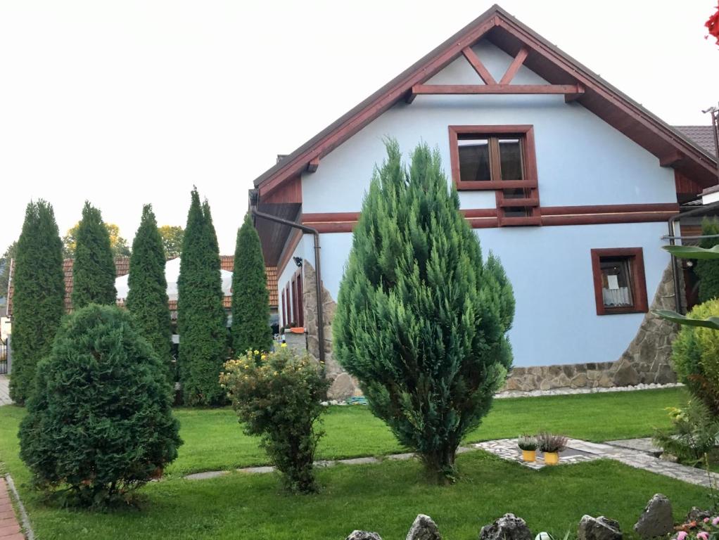 dom z drzewami przed nim w obiekcie Penzion SATY w mieście Liptovské Sliače