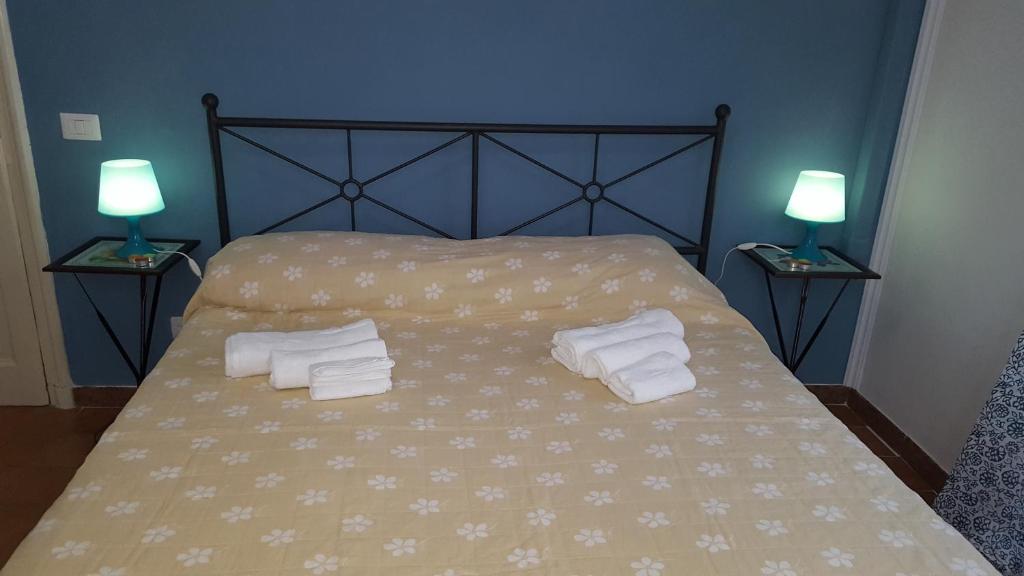 a bedroom with a bed with two towels and two lamps at La Casa di Nonna Rosa in Rome