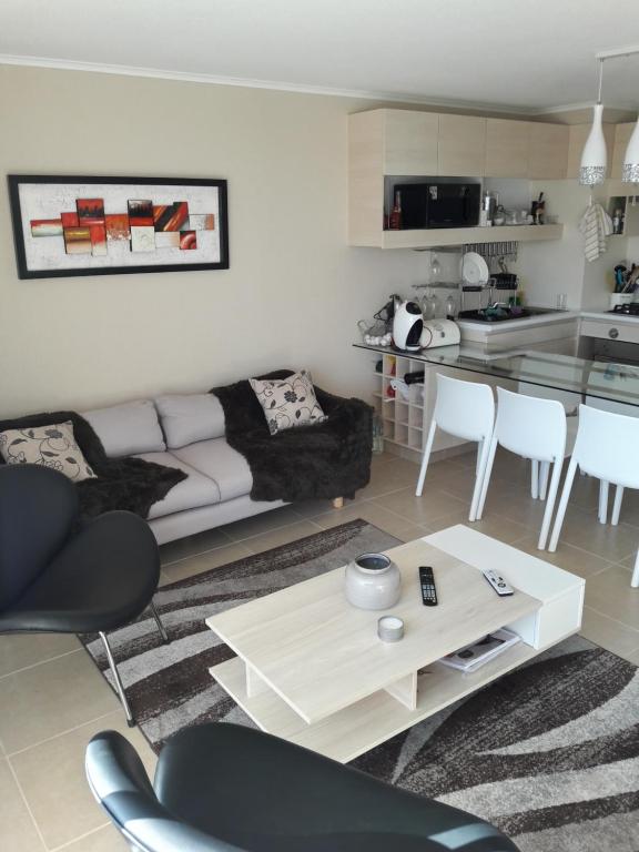 a living room with a couch and a table at Laguna Bahía Algarrobo Valparaiso in Algarrobo