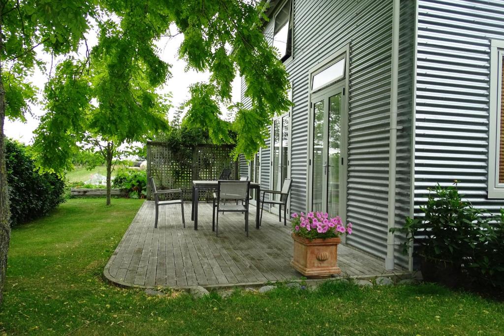 een patio met een tafel en stoelen naast een huis bij Korohi Vineyard BnB in Blenheim