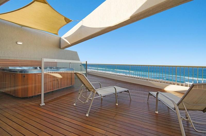 eine Terrasse mit zwei Stühlen und einem Tisch auf einem Schiff in der Unterkunft Costa Nova Holiday Apartments in Sunshine Beach