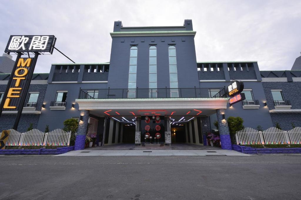un edificio azul con un cartel delante en OUGE Boutique Motel - Pingtung en Jiuru