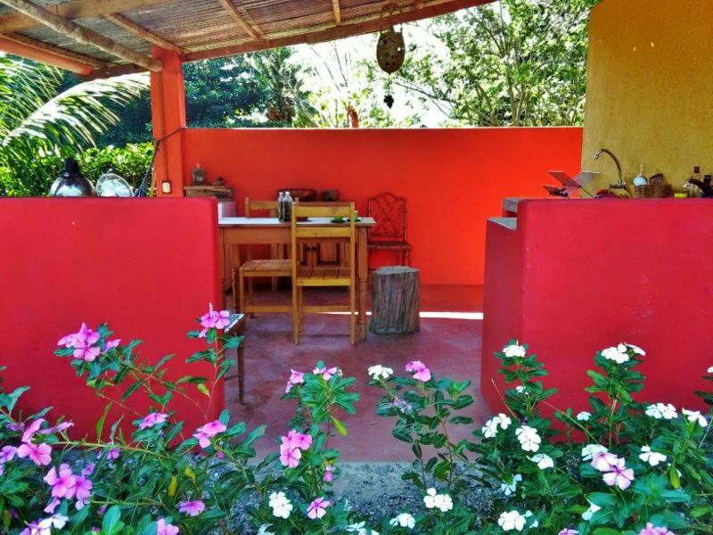 czerwone patio ze stołem i kwiatami w obiekcie Puka Wasi Posada w mieście Tarapoto