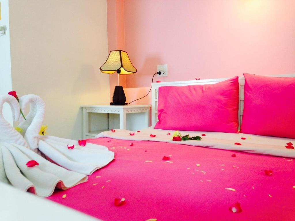 Dormitorio rosa con cama cubierta de confeti en Ben's House, en Ao Nang Beach