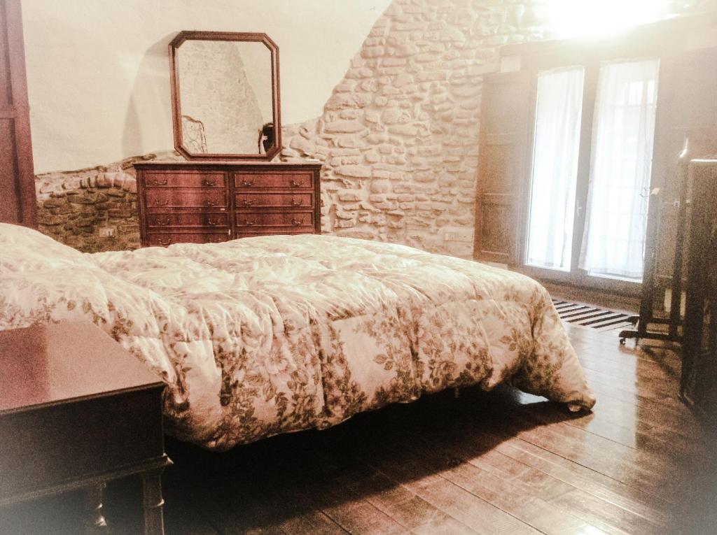 1 dormitorio con cama, tocador y espejo en Il Torretto en Brisighella