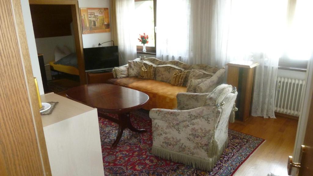ein Wohnzimmer mit einem Sofa und einem Tisch in der Unterkunft Ferienwohnung Gilching in Gilching