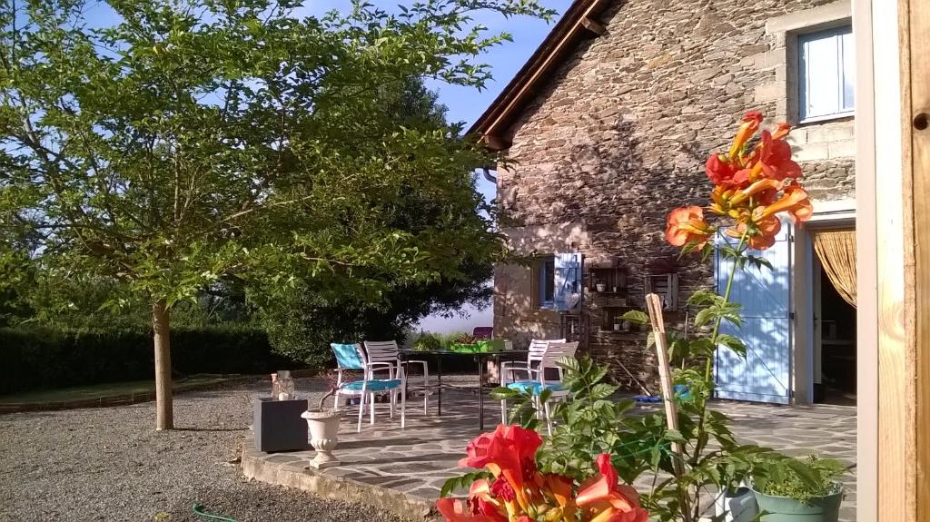 Mirandol-BourgnounacにあるGîte de La Maison Bleueの建物の前に椅子と花が並ぶパティオ