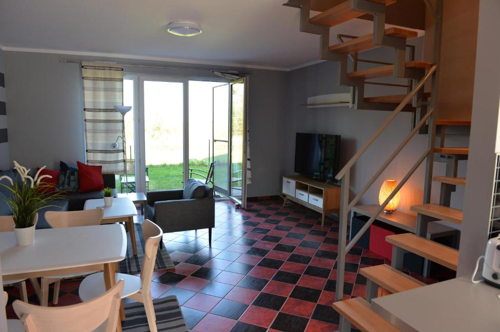 ein Wohnzimmer mit einer Treppe, einem Tisch und Stühlen in der Unterkunft Apartament Babitonga II in Puck