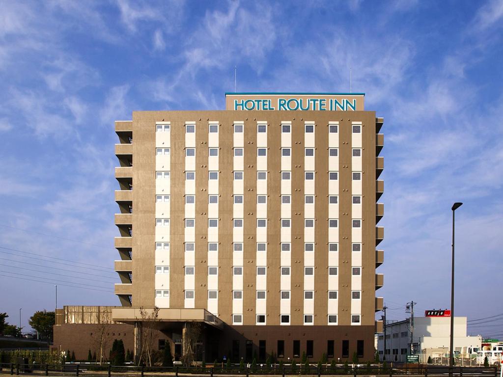 a hotel building with a hotel route inn on top at Hotel Route Inn Toyama Inter in Toyama