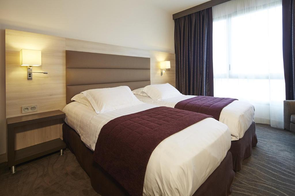 Postel nebo postele na pokoji v ubytování Kyriad Prestige Lyon Est - Saint Priest Eurexpo Hotel and SPA