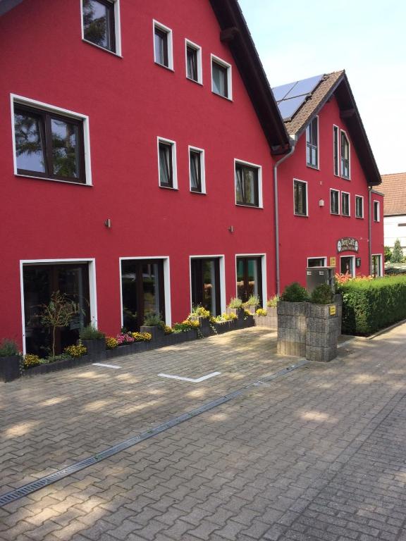 a red building with a driveway in front of it at Bergcafè - Hotel Kammann in Essen