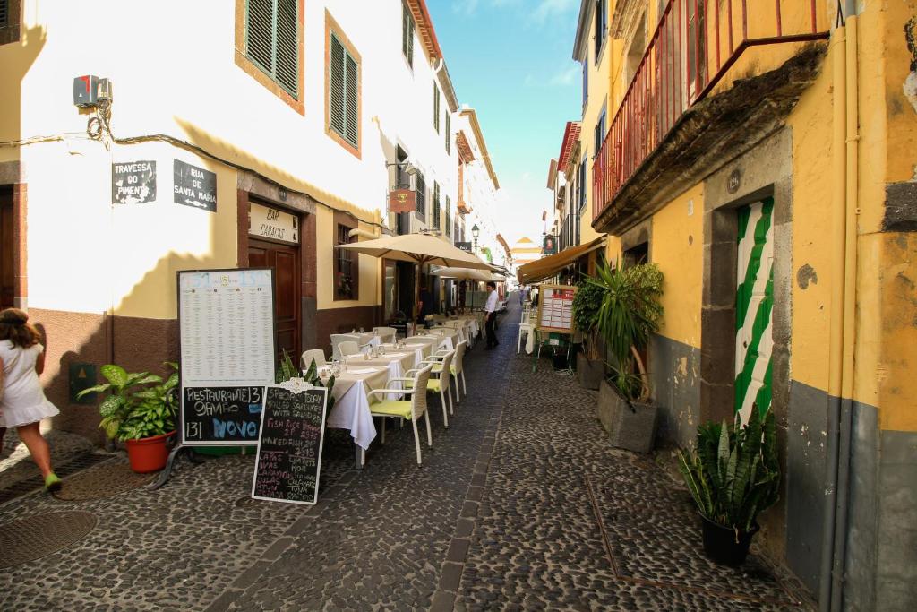 uma rua com mesas e cadeiras num beco em Casa Maria em Funchal