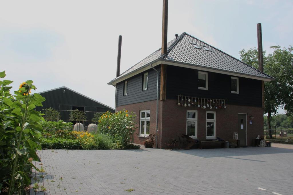 a house with a black roof and a courtyard at Bed and Breakfast De Volkelse Hooiberg in Volkel