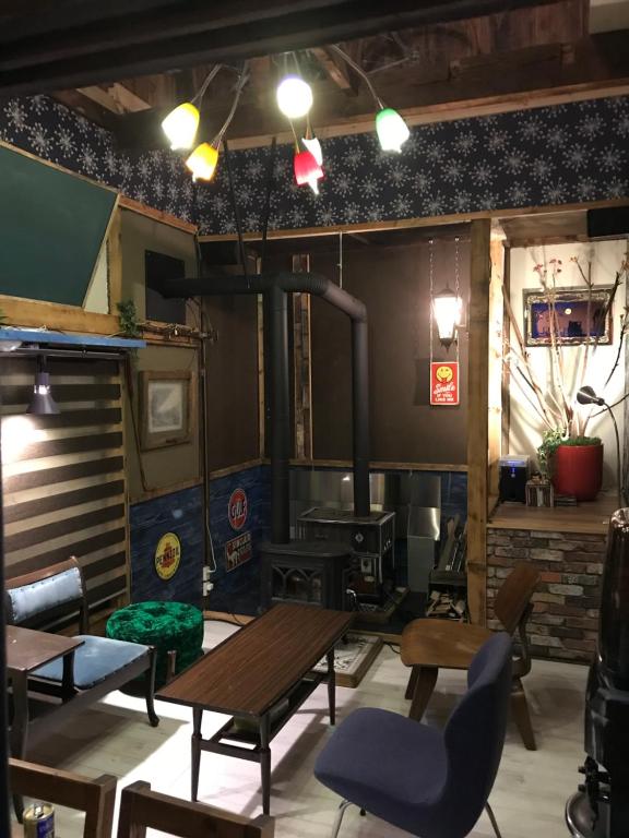 a room with tables and chairs and a wood stove at Shabby House in Sapporo