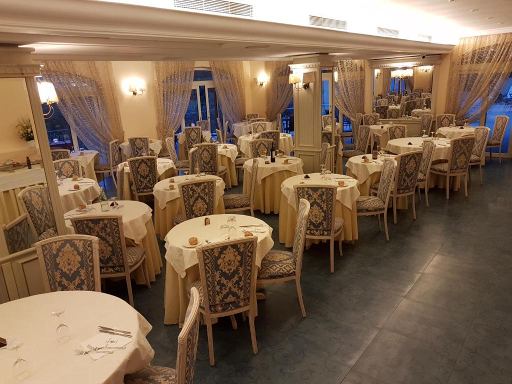 jadalnia z białymi stołami i krzesłami w obiekcie Hotel La Vue d'Or w Sorrento