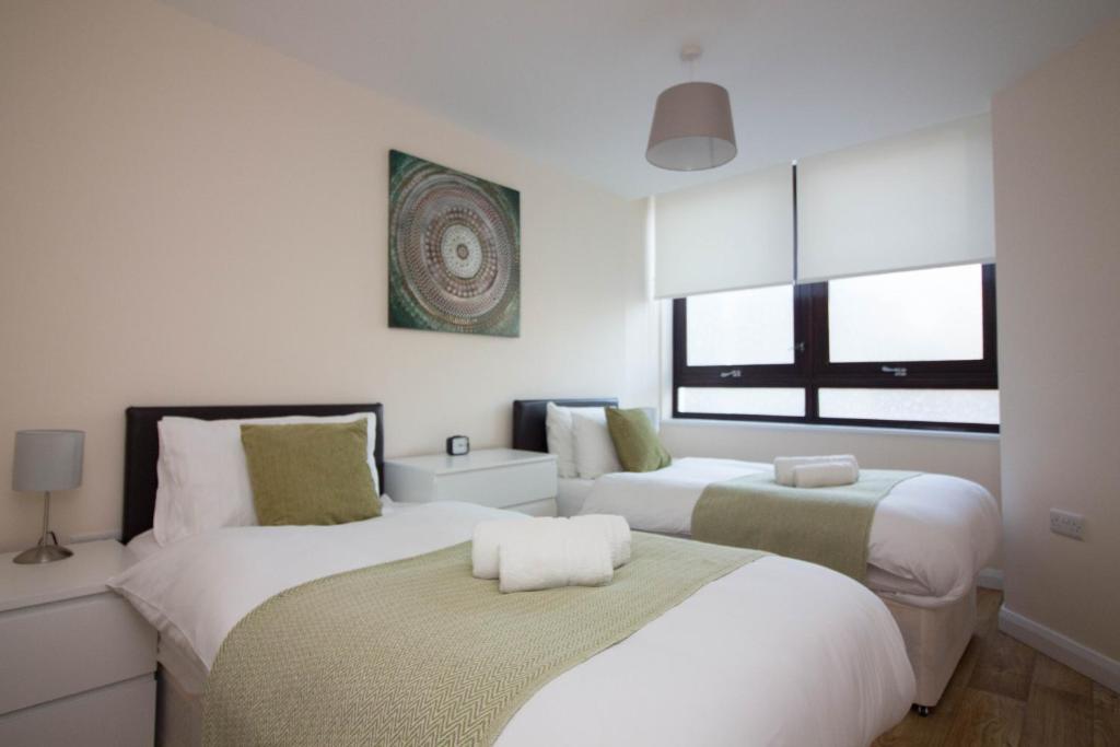 1 dormitorio con 2 camas y ventana en Castle Point Apartments Southampton Premier Lodge en Southampton