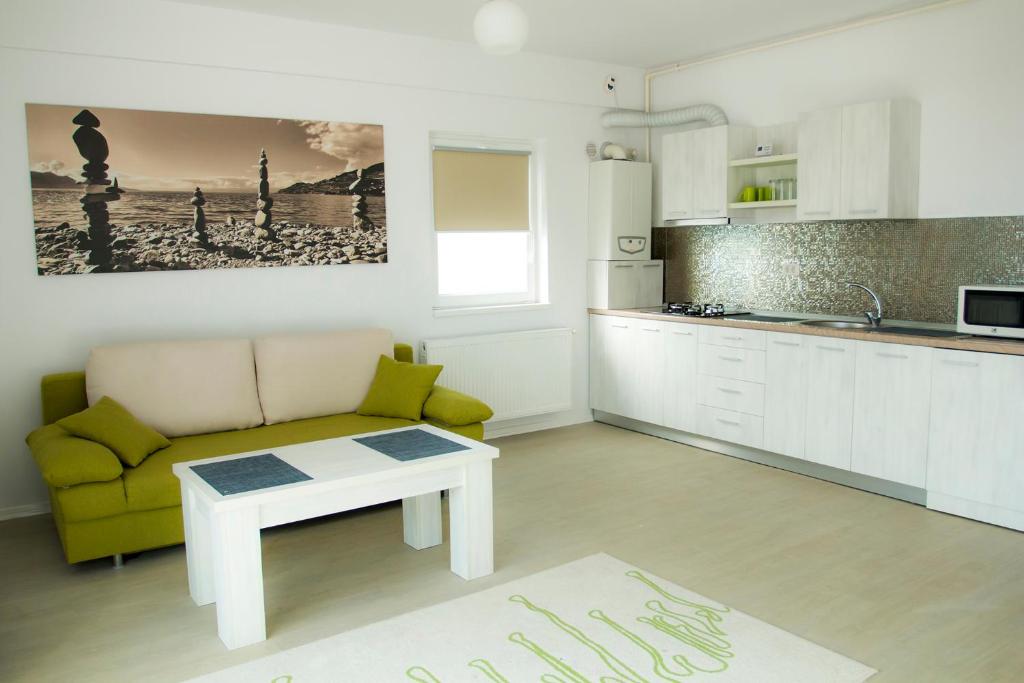 ママイア・ノルドにあるGreen 24 Apartmentのリビングルーム(ソファ、テーブル付)、キッチンが備わります。