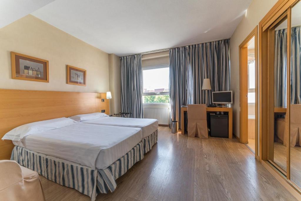 pokój hotelowy z łóżkiem i telewizorem w obiekcie Infanta Mercedes w Madrycie