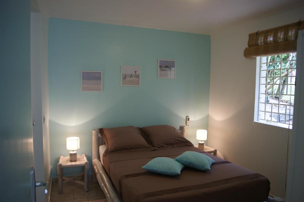 1 dormitorio con 1 cama con 2 almohadas en Résidence Anamanga, en Sainte-Anne