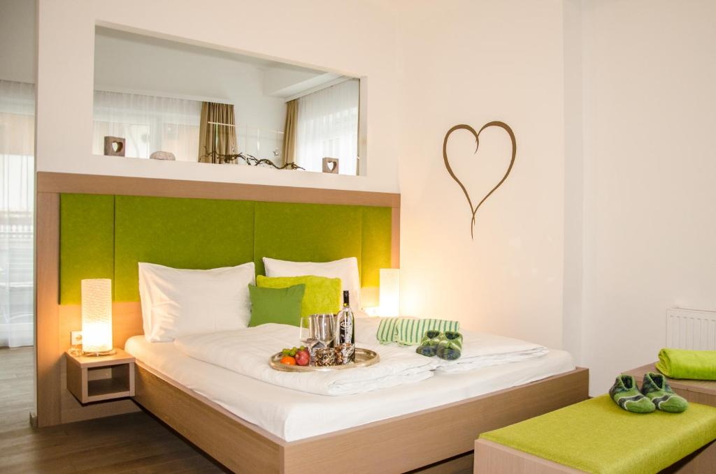 1 dormitorio con 1 cama con un corazón en la pared en Aparthotel Bergtraum, en Mühlbach am Hochkönig