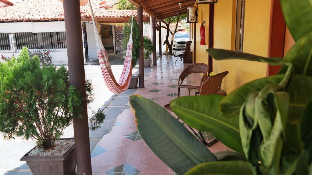 a porch with chairs and plants in a building at Pousada Beira Rio Parnaíba in Parnaíba