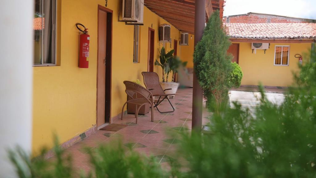 a patio with chairs and a table and a building at Pousada Beira Rio Parnaíba in Parnaíba