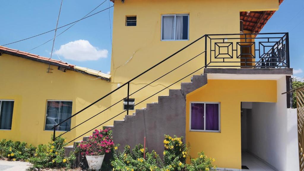 a yellow building with stairs in front of it at Pousada Beira Rio Parnaíba in Parnaíba