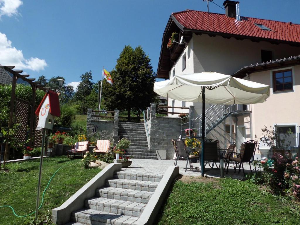 eine Terrasse mit einem Sonnenschirm, einem Tisch und Stühlen in der Unterkunft Fewo-Lenz in Hermagor