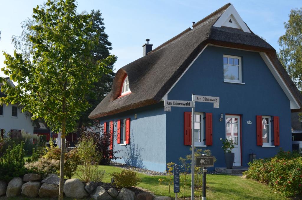 a blue house with a gambrel roof at Ferienhaus Vier Jahreszeiten in Glowe