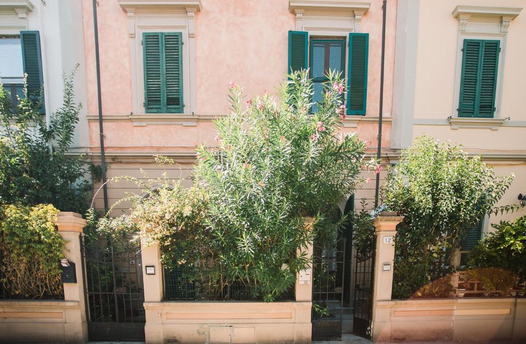 a building with a fence and trees in front of it at La Casetta Di Filippo E Chiara in Pisa