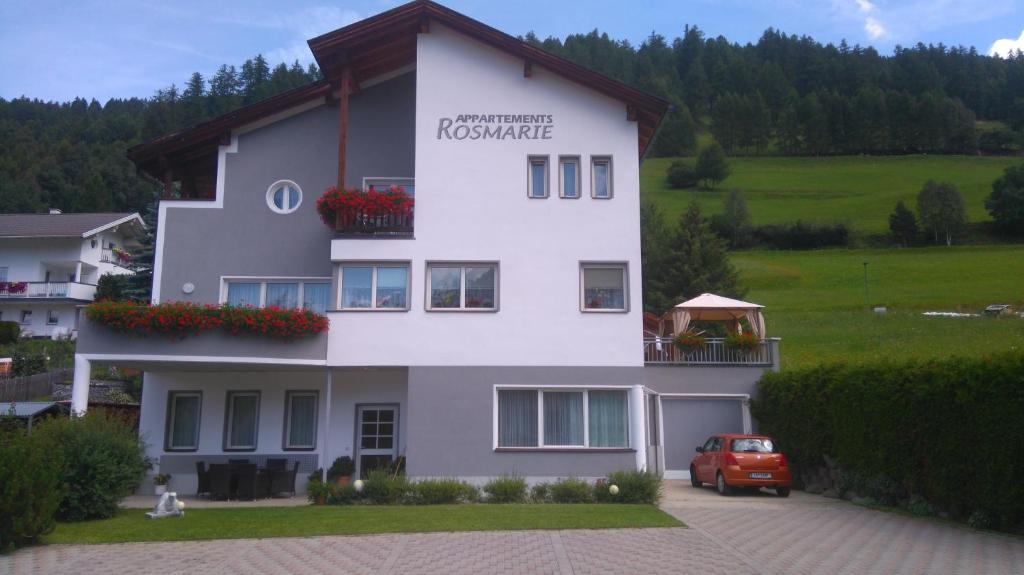 a building with a red car parked in front of it at Appartements Rosmarie in Fendels