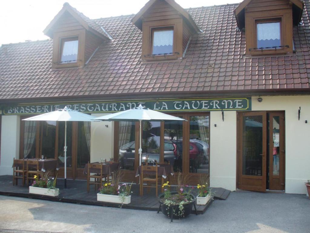restauracja ze stołami i krzesłami przed budynkiem w obiekcie La Taverne w mieście Buire-le-Sec