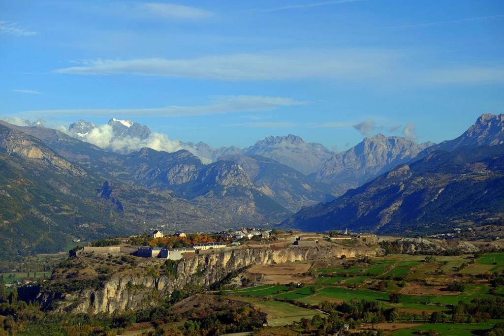 - une vue sur une chaîne de montagnes avec une ville sur une colline dans l'établissement La Maison de Joséphine, à Risoul