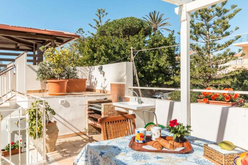 a table with food on top of a patio at La Casa di Romi in Marina di Ragusa