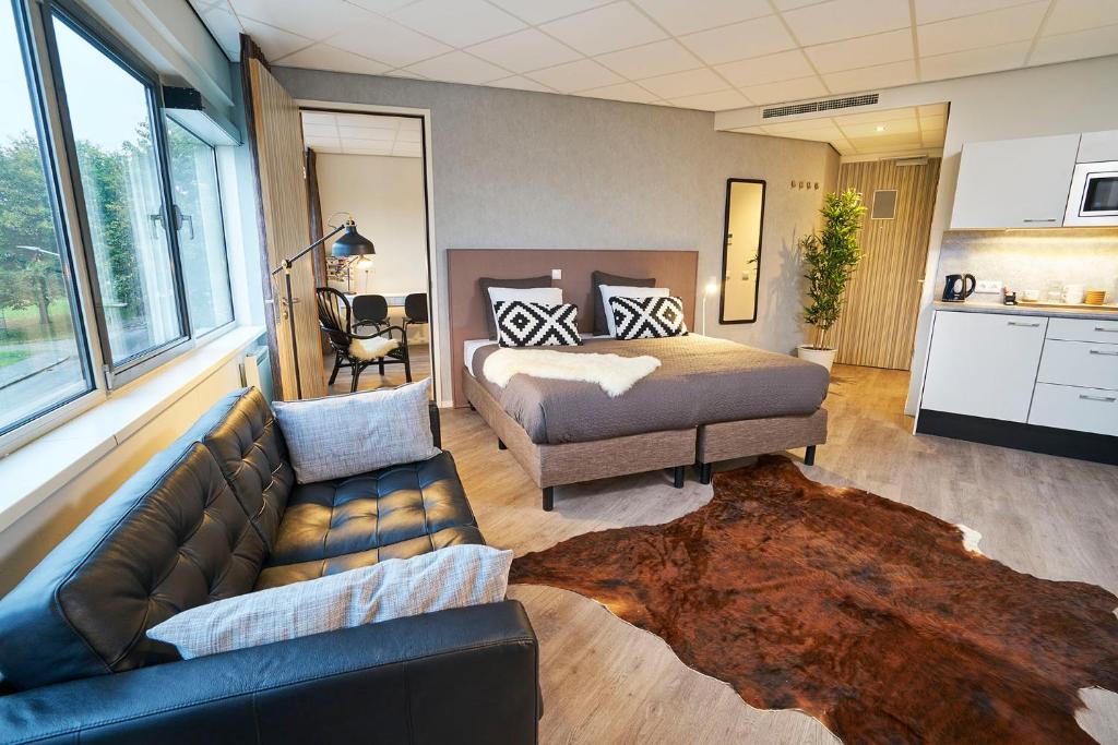 a living room with a couch and a bed at Amrâth Apart-Hotel Schiphol Badhoevedorp in Badhoevedorp