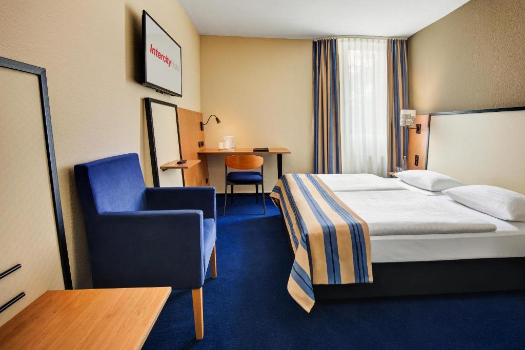 une chambre d'hôtel avec un lit et une chaise dans l'établissement IntercityHotel Celle, à Celle