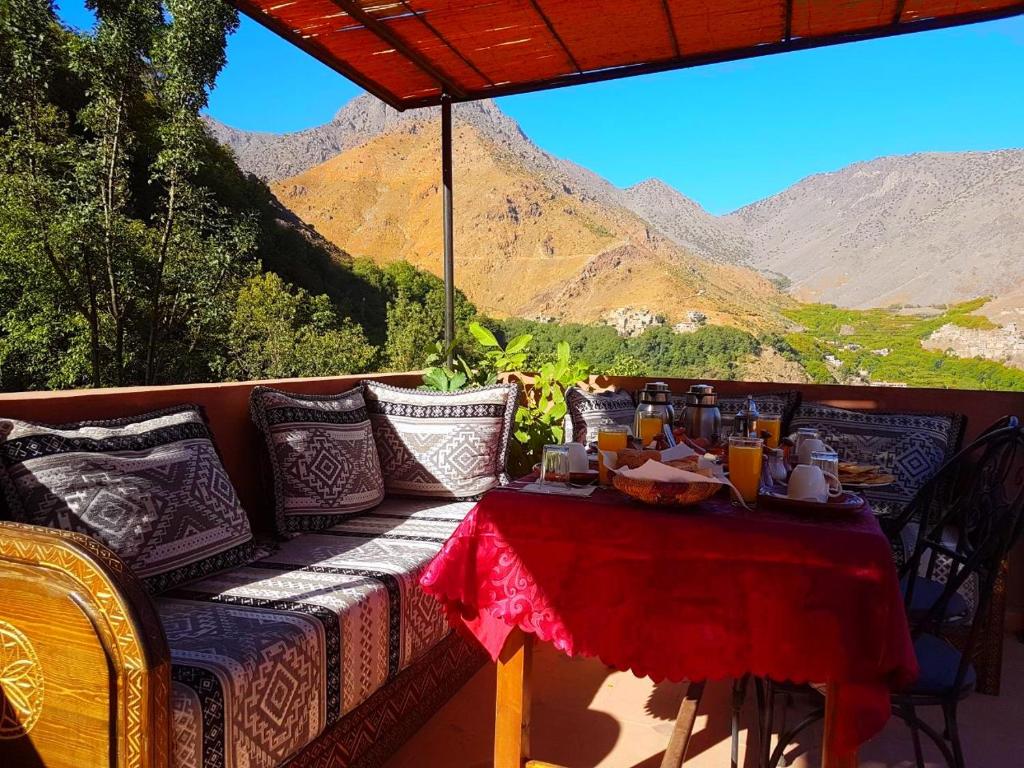 una mesa en un balcón con vistas a las montañas en Atlas Imoula en Imlil