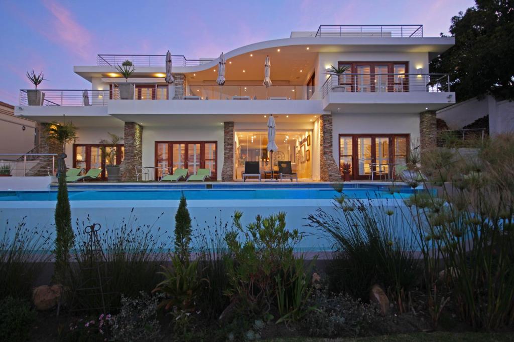 a large house with a swimming pool in front of it at Aquavit Guest House in Plettenberg Bay