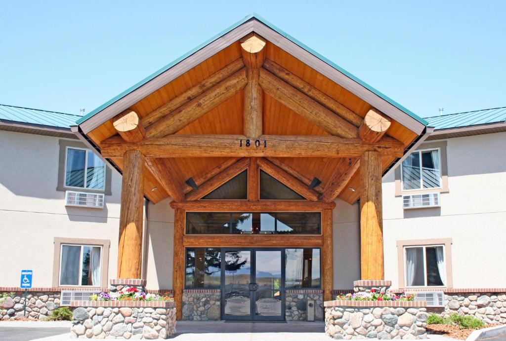 a large wooden pavilion in front of a building at Cody Legacy Inn & Suites in Cody
