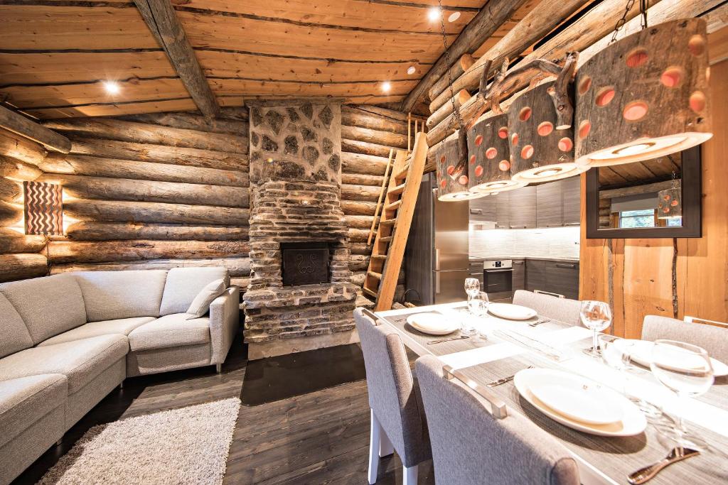 a dining room with a table and a fireplace at UnelmaKelo in Ruka