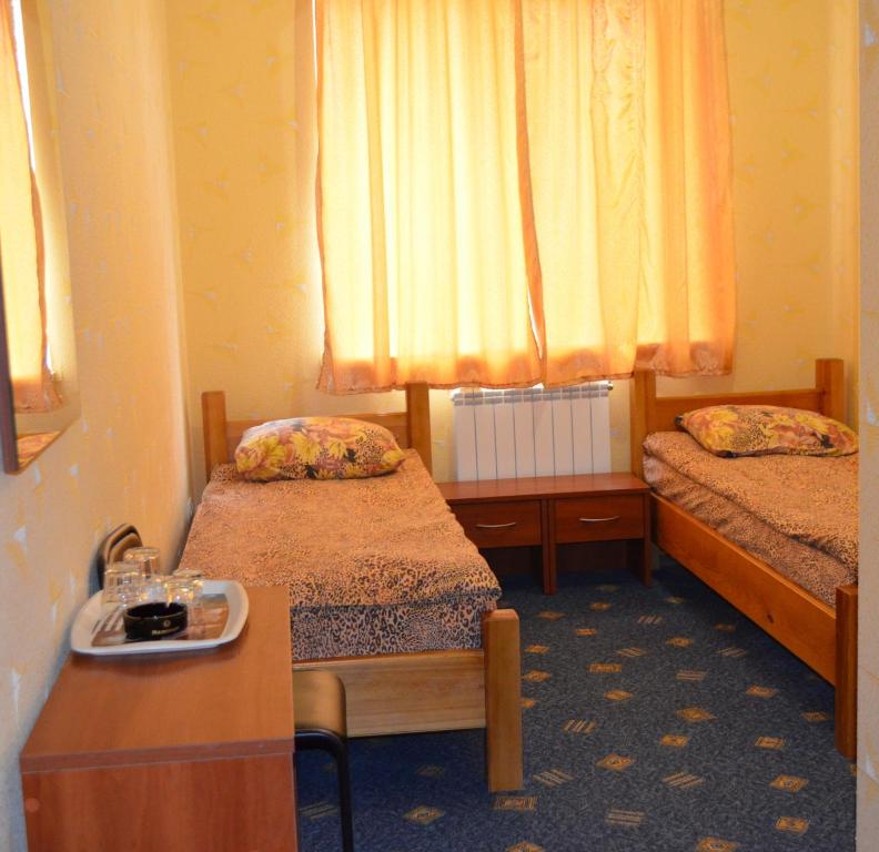 Habitación pequeña con 2 camas y mesa. en Sfinks, en Zaporozhye